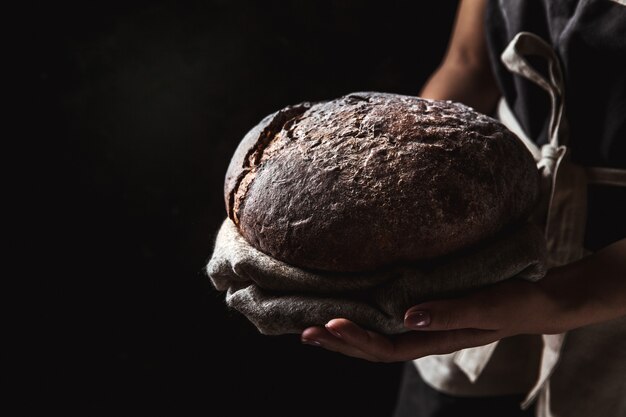 Rustic bread in baker hand, healthy food