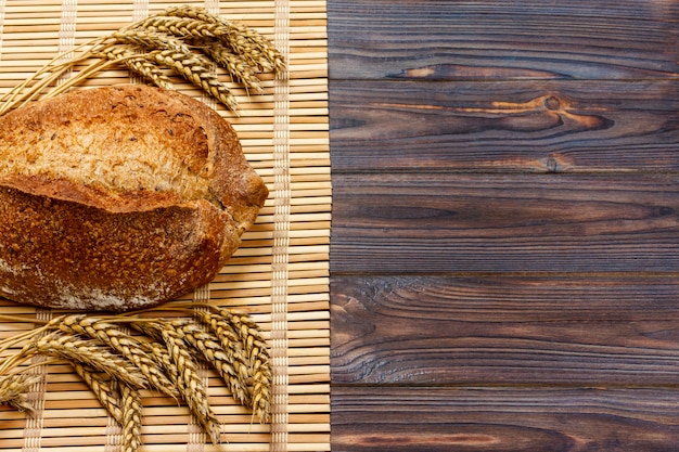 Rustic bread and wheat on an old vintage planked wood table. background with copyspace