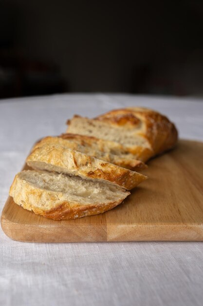 Photo rustic charm captured in sliced french bread on a wooden board a simple yet inviting scene showcas