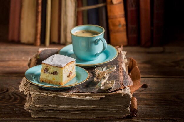 Rustic cheesecake and coffee on book in library