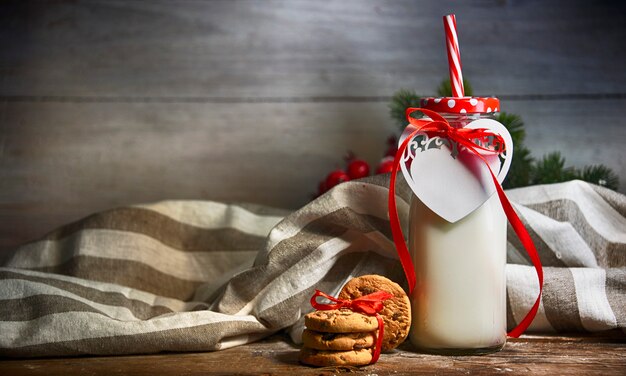 Sfondo di natale rustico con latte e biscotti a babbo natale