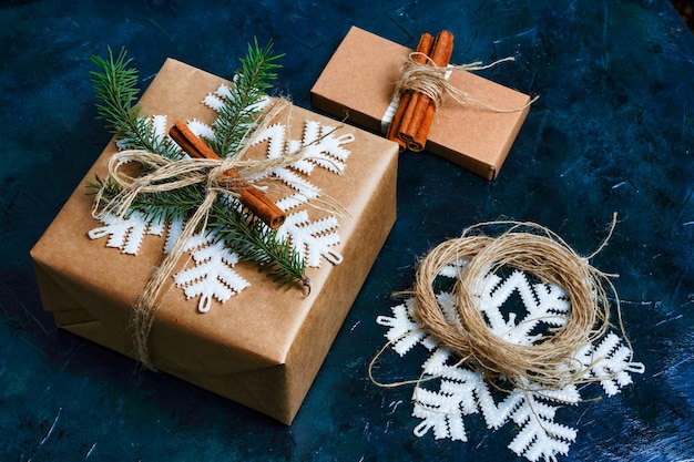 Деревенская рождественская подарочная коробка с елочными украшениями на зеленом фоне метод завернутого новогоднего п ...