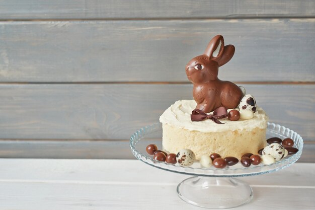 Photo rustic easter cake with chocolate bunnies and eggs.