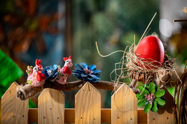 ルスティック・イースター・コンポジション 手作りの巣 赤い卵と奇妙な鳥の像