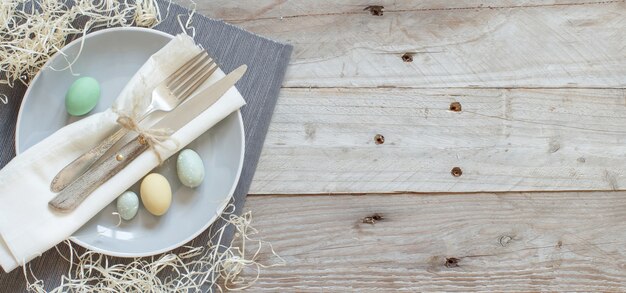 Деревенская пасхальная сервировка с яйцами на деревянном столе