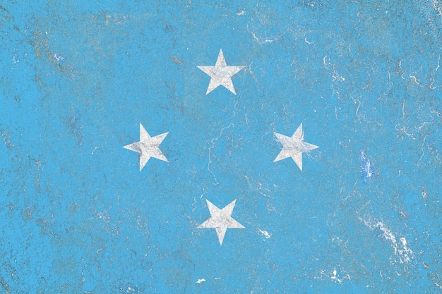 Деревенский флаг федеративных штатов микронезии нарисован на поврежденной поверхности старой бетонной стены