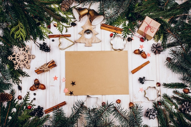 Rustic paper lies in the center of a circle made of fir tree branches and rustic Christmas decor 