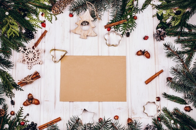 Rustic paper lies in the center of a circle made of fir tree branches 