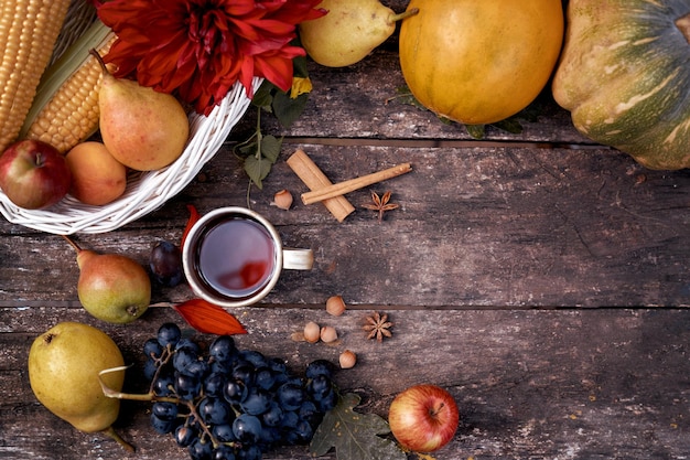 Rustic still life cup of tea fruits vegetables hazelnuts and cinnamon sticks