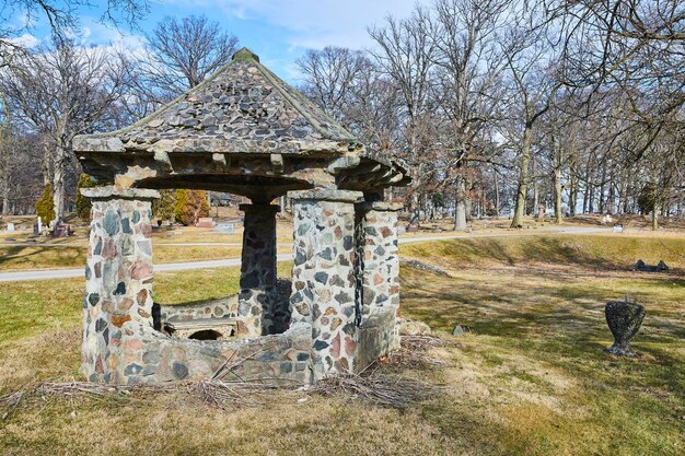 Foto rustic stone well in serene cemetery park lindenwood indiana