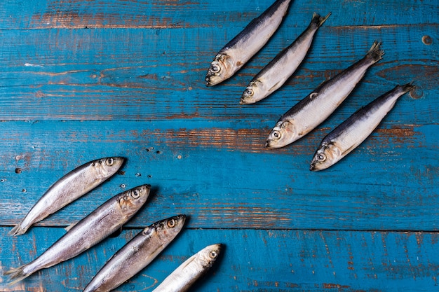 Rustic style. Fish pattern. Herring fish on an old blue wooden background, flat lay, copy space.