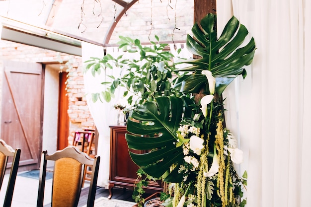 Rustic wedding decoration. Monstera leaves in a wedding decor.