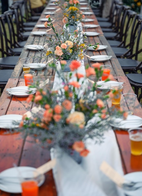 Rustic wedding style Wooden dining table with flowers decoration and tableware