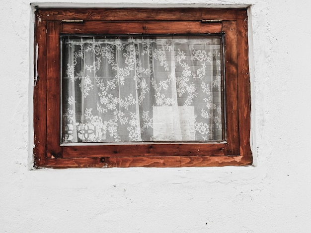 Rustic window with white lace curtains. old vintage window\
grunge cement wall