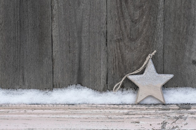 Priorità bassa di inverno rustico con stella di natale in legno