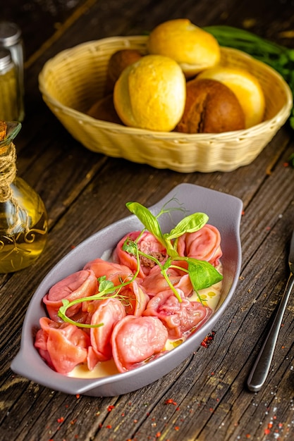 Foto fondo di legno rustico, superiore e laterale, su un piatto, gnocchi fatti in casa, colore rosa, verdure e