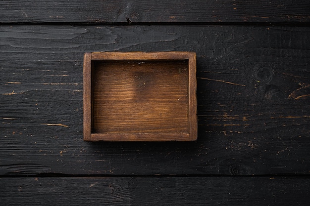 Photo rustic wooden box or container set with copy space for text or food, top view flat lay, on black wooden table background