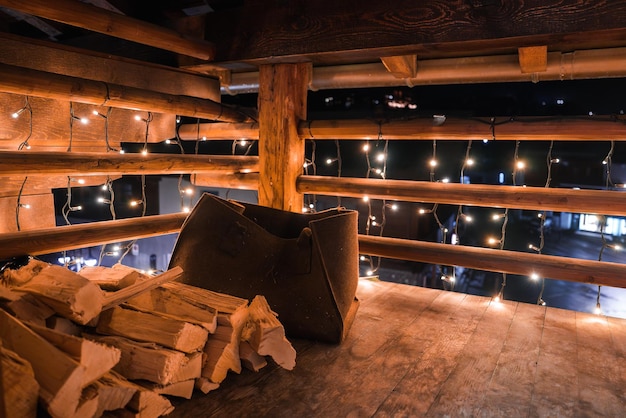 Рустический деревянный ящик с дровами и струнными огнями в уютной крытой каюте