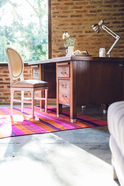 Rustic wooden desk and antique chair in the living room\
decorated in a rustic and modern style