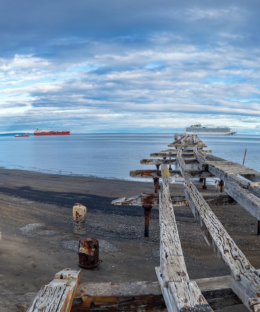 Foto il molo di legno rustico che conduce al mare tranquillo con le navi