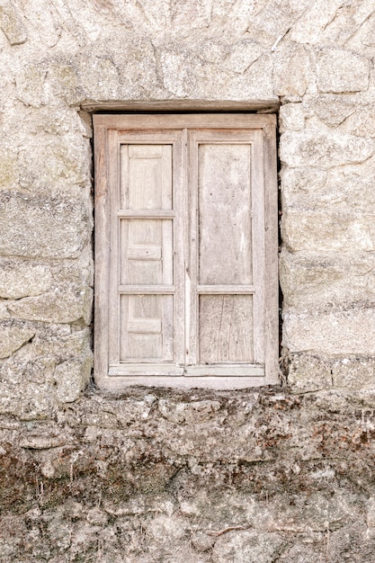 Finestra in legno rustico nella vecchia casa di pietra