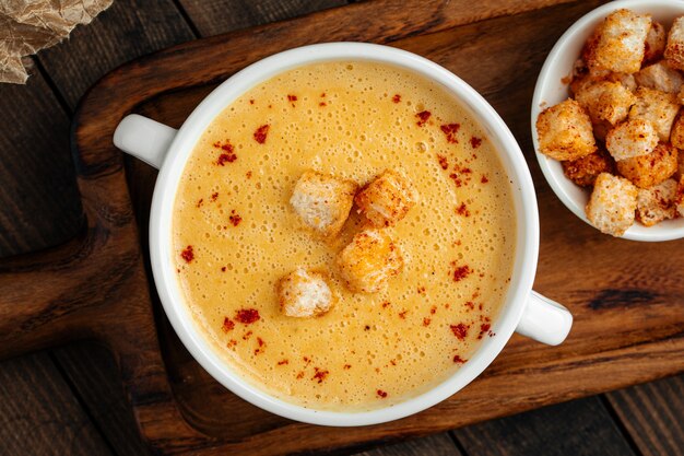 Rustic yellow chicken cream soup with croutons