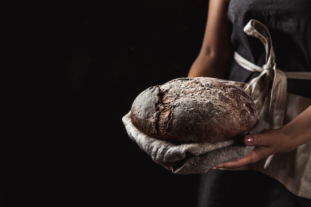 Rustiek brood in bakkershand, gezond voedsel