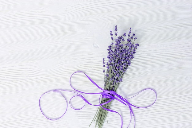 Foto rustieke achtergrond met lavendel bloemen op witte houten oppervlak. selectieve aandacht.
