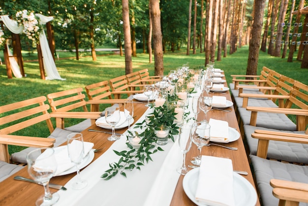 Foto rustieke groene tak en kaarsen op tafel. bruiloft decoratie.
