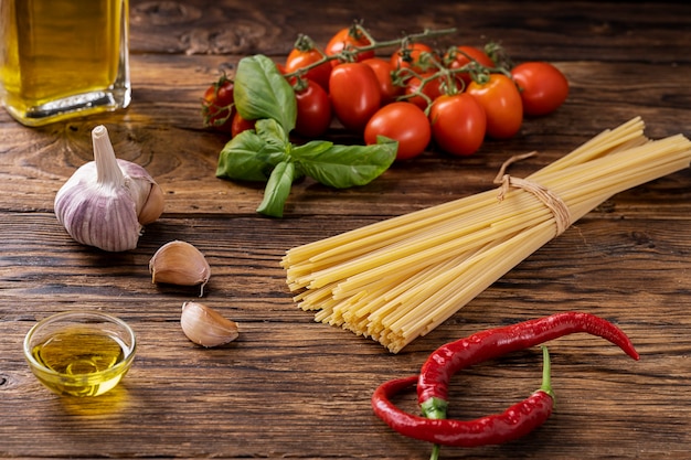 Rustieke houten plank met rauwe ingrediënten om pasta op Italiaanse wijze op smaak te brengen