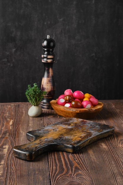 Rustieke keukentafel met verse groenten en pepermolen op de achtergrond