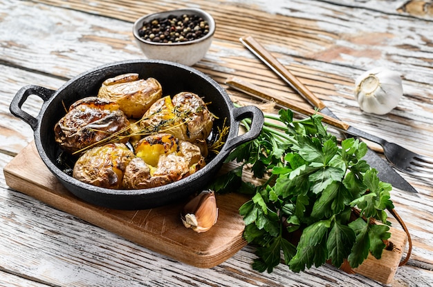 Rustieke oven gebakken aardappelen met rozemarijn. Organische groenten. Witte achtergrond. Bovenaanzicht
