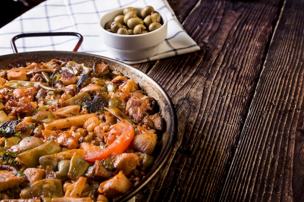 Rustieke tafel met paella en groene olijven. Heerlijk traditioneel eten, smaken van de wereld?