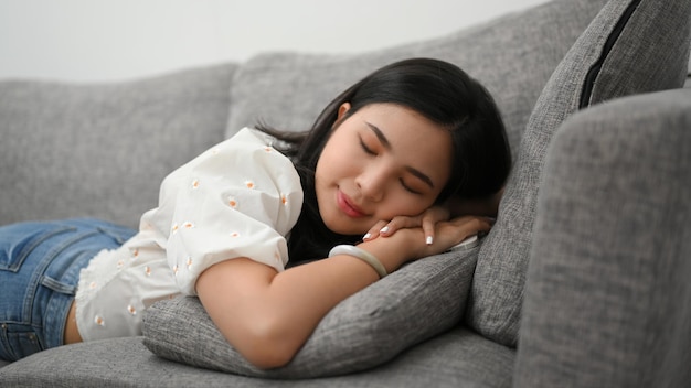 Rustige ontspannen vrouw liggend op een comfortabele bank in haar woonkamer slapen een dutje doen rusten