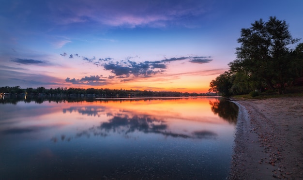 Rustige scène met rivier en kleurrijke hemel met wolken bij zonsondergang