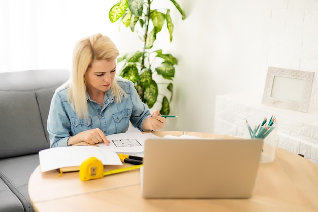 Rustige slimme vrouw die in de slaapkamer voor een camera op statief staat en een rol papier vasthoudt.