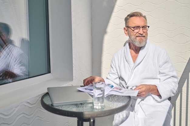 Rustige vakantieganger zittend op het balkon in de verte starend