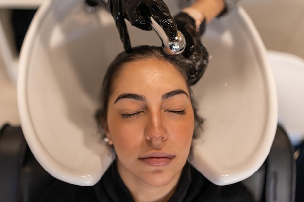 Rustige vrouw die haar in de gootsteen wast