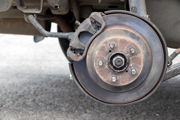 Rusty back car wheel hub with brake disc at tire shop