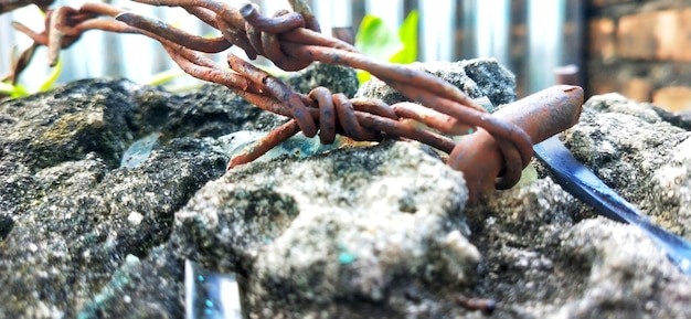 Photo rusty barbed wire tied between the cement cast and the stone