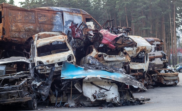 Rusty burnt cars destroyed by rocket explosions War in Ukraine Destroyed vehicles of civilians who