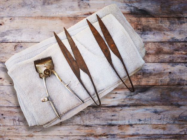 Rusty and dirty tools on wood background at barbershop.