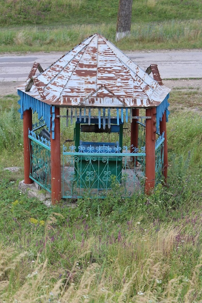 Photo a rusty gazebo in a grassy area