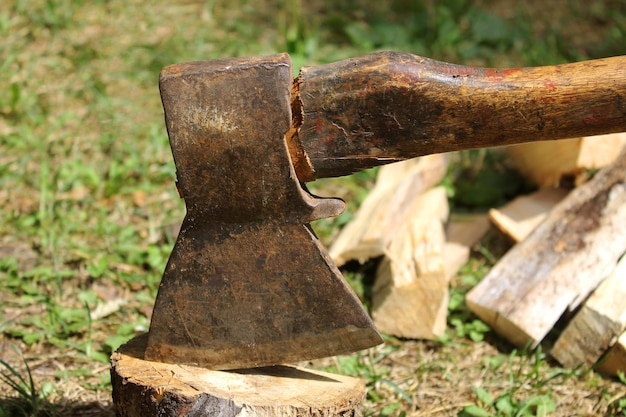 rusty hand an ax is driven into a tree against the background of camping tents, an ax in a board