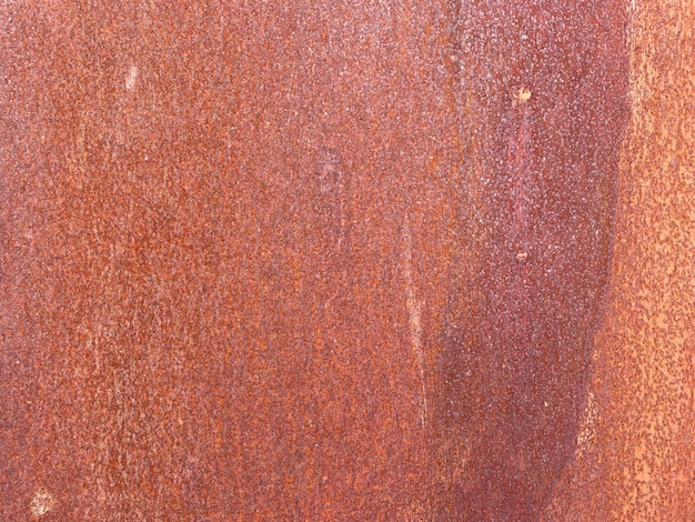 A rusty metal wall with a white spot on it.