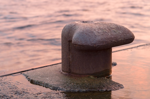 Photo rusty mooring bollard by the river