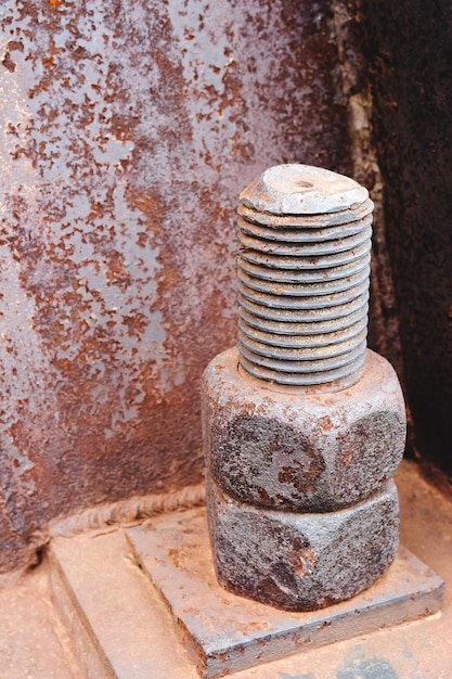 Rusty nuts and threaded stud on base of frame