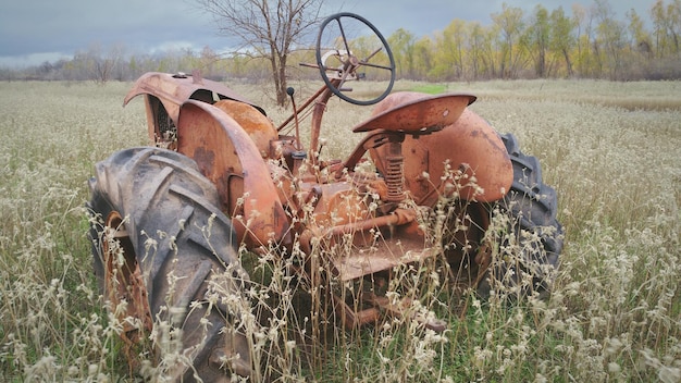 Photo rusty old abandoned tractor in field