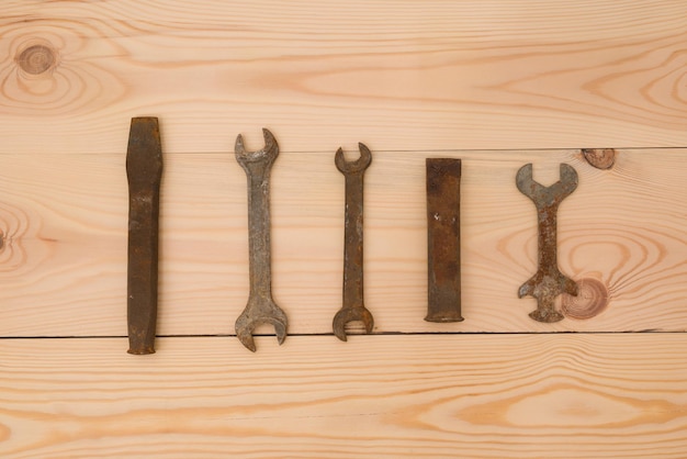 Rusty old open end wrenches chisels on a wooden background