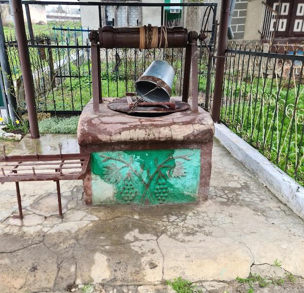 A rusty old water pump with a green leaf pattern on the front.